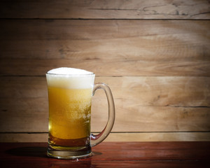 Cool beer on wood background.