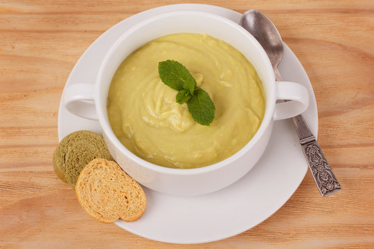 Vegetable cream soup with mint and bread.