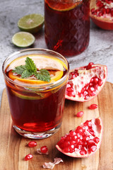 glass of pomegranate drink with fresh  citrus fruits