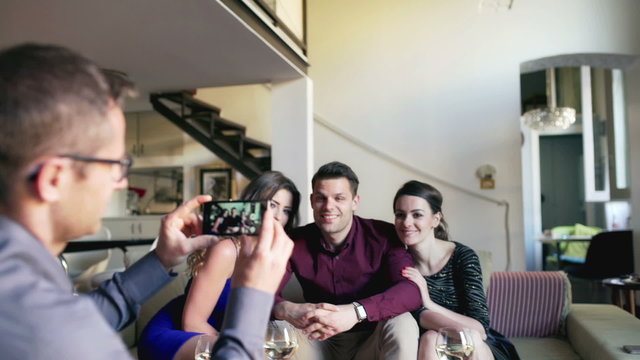 Man doing photo on smartphone of his friends, steadycam shot

