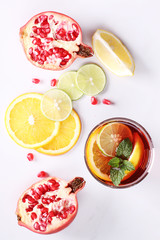glass of pomegranate drink with fresh citrus fruits