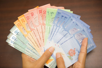 hand holding with Malaysian money banknotes