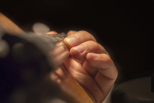 Man's hand on a violin fingerboard