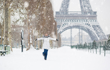 Winter in Paris. Happy young girl jumping - obrazy, fototapety, plakaty