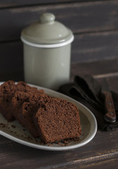 pieces of chocolate cake on the oval dish on dark wooden background