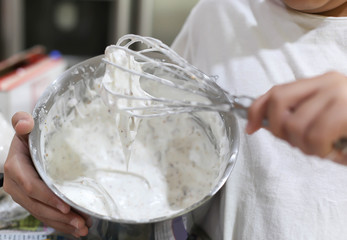 Fototapeta na wymiar Young boy mixing flour with whisk