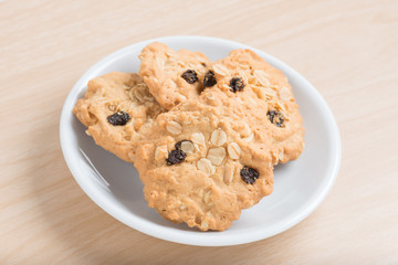 Oatmeal and raisin cookies on white dish.