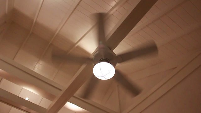 A ceiling fan in a house in action at night