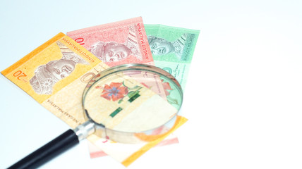 Magnifier with Malaysia bank notes.concept photo.