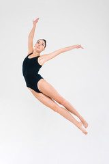 Fototapeta premium Woman in gymnast suit doing acrobatic stunt