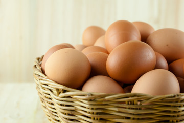 Full of Eggs put in a wicker basket in wooden background