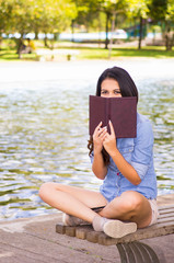 Brunette model wearing denim shirt and white shorts relaxing in