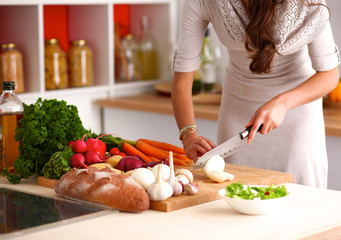 Young woman reading cookbook in the kitchen, looking for recipe