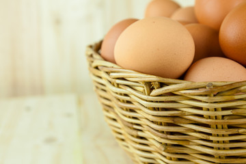 Full of Eggs put in a wicker basket in wooden background