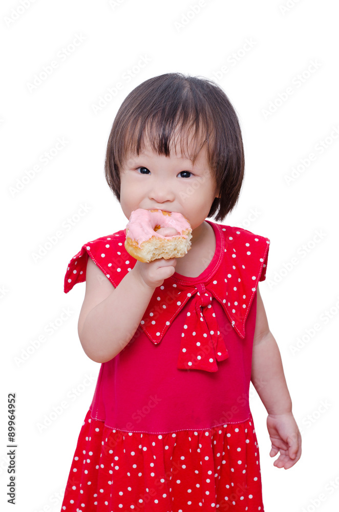 Wall mural Little Asian girl eating donut over white