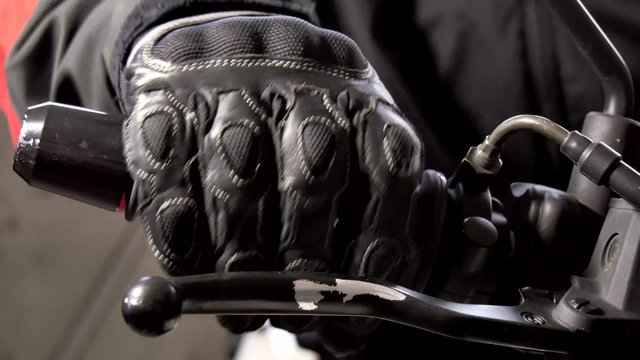 man checks motorbike handle
