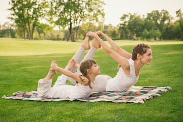 Mother with daughter doing yoga exercise