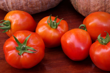 Group of tomatoes on wooden background.