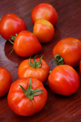 Group of tomatoes on wooden background.