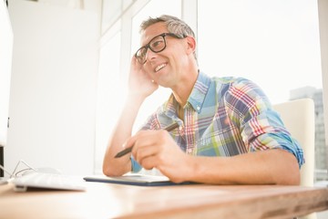Smiling casual designer using computer and digitizer