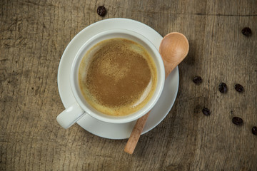 Coffee cup with wooden spoon and coffee beans