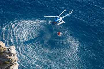 Zelfklevend Fotobehang Helikopter Brandweerhelikopter verzamelt water over zee