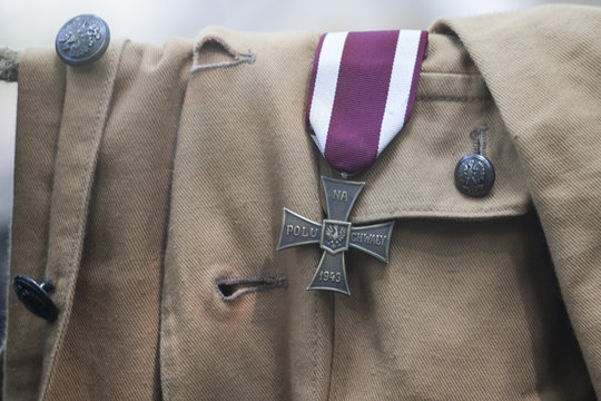 Polski Krzyż Walecznych przypięty do historycznego munduru żołnierza Wojska Polskiego