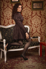 Beautiful woman in a black dress in the vintage interior