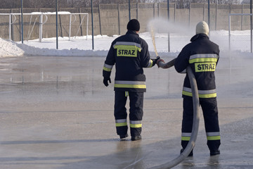 strażacy robiący zimą lodowiska