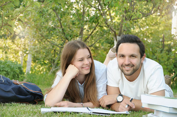 couple of young students studying in the park