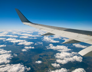 Obraz premium Wing of the plane on blue sky