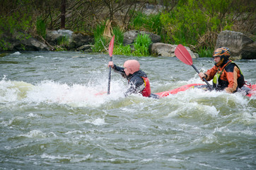 kayakers paddling hard the kayak with lots of splashes