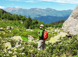 Fototapeta na wymiar Man hiking in the mountains on a tourist track near a lake