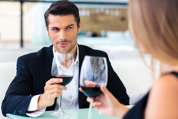 Man drinking red wine with his girlfriend