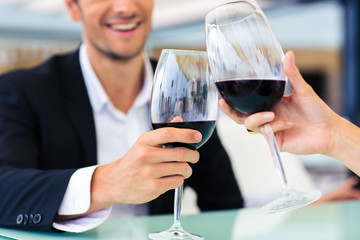 Man drinking red wine in restaurant