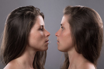 Two Serious Twin Sisters Looking at Each Other