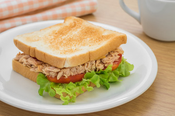 Tuna sandwich on plate and coffee cup