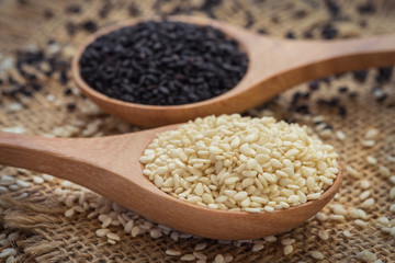 White sesame and black sesame seed on wooden spoon