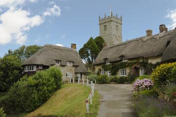 The pretty thatched cottages of Church Hill, with All Saints church in the background.l