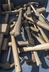 A selection of old hammers and mallets in a box at a car boot sale
