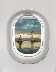 Looking out the window of a plane to the lighthouse in Lindau