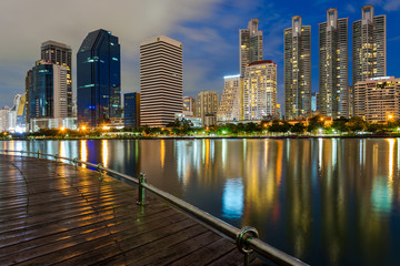 Naklejka premium Business buildings in Bangkok seen from Benjakiti park, night Sc