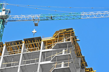 Crane and building construction site against blue sky