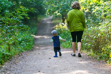 Fototapeta premium Little boy and mother running and playing in forest at summer.