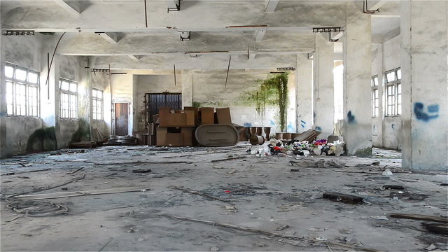 undecrorated industrial loft in an architectural background with bare cement walls, rubbish on floors, zooming in