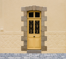 Moderne Haustür aus Holz mit Schmiedeeisen in gelber Farbe