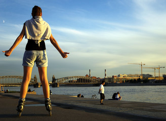 Woman rollerblading in summer evening on the town © seesta812