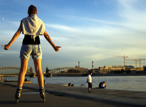 Woman rollerblading in summer evening on the town