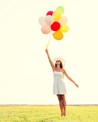 Fototapeta na wymiar smiling young woman in sunglasses with balloons