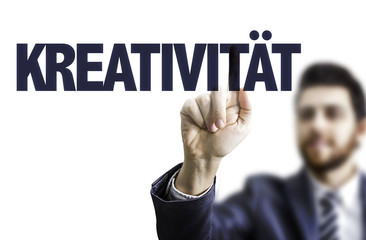 Businessman pointing the text: Creativity (in German)